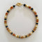 Necklace with multicolored beads and gold accents on a light gray background