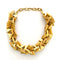 Gold necklace with geometric design on a white background