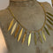 Gold leaf necklace on a mannequin bust with a plain background