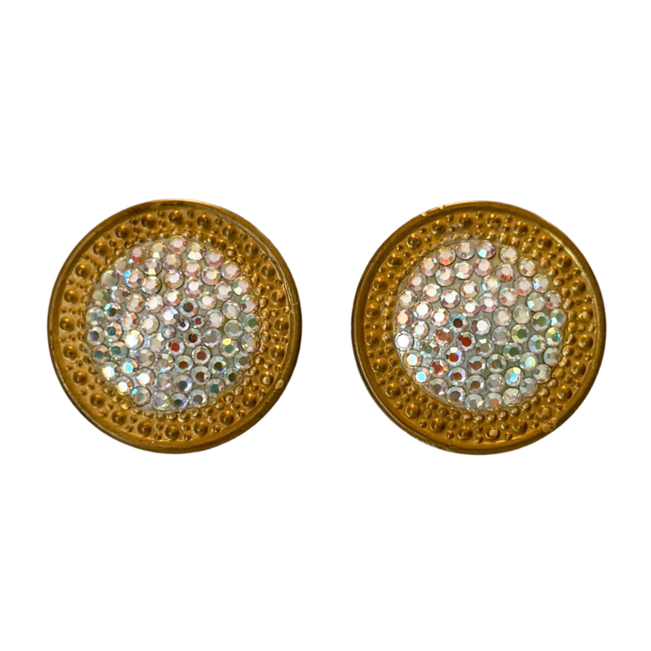 Pair of round gold earrings with gemstone-like center on a gray background