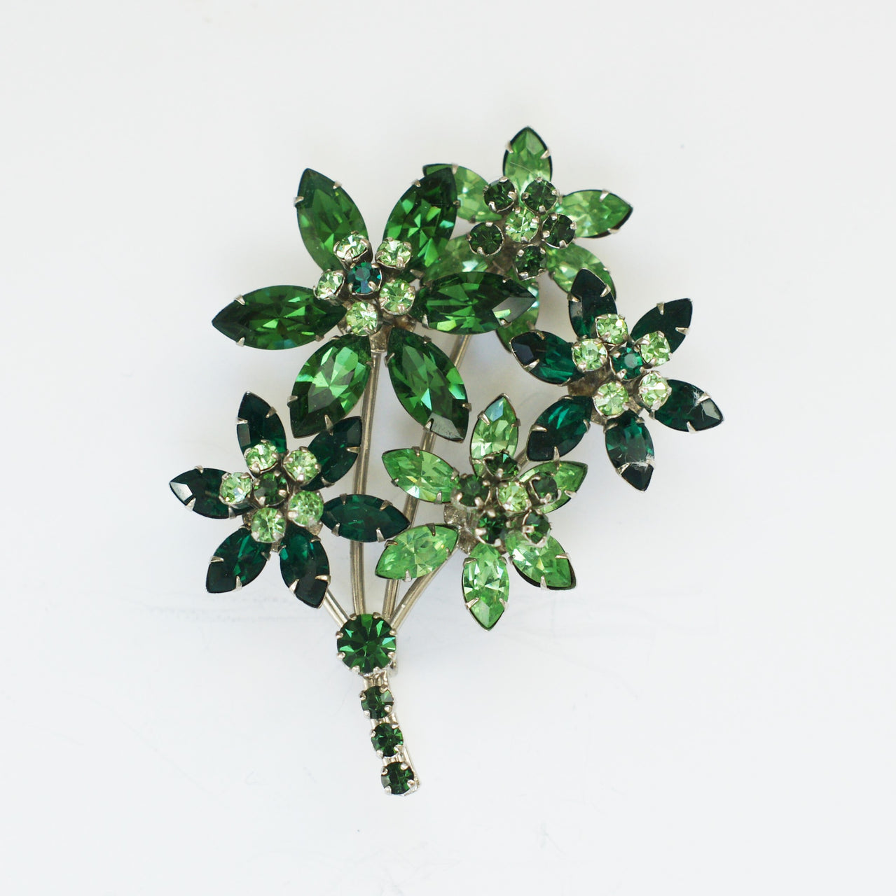 1950s vintage green rhinestones flower brooch on white background