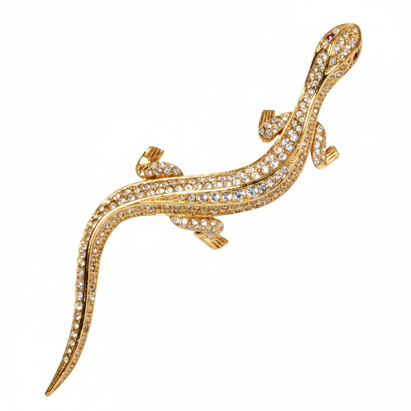 Silver lizard-shaped brooch with gemstones on a white background