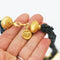 plaited black beads and matt gold plated front vintage necklace on white background close up of clasp