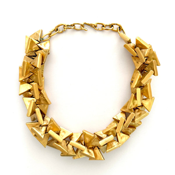 Gold necklace with geometric design on a white background