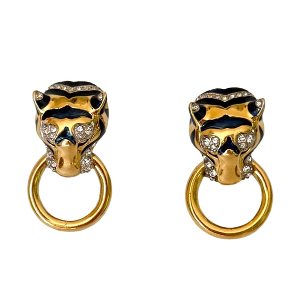 Pair of gold and black tiger head earrings on a light gray background