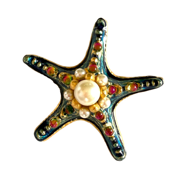 Starfish-shaped brooch with pearl center and colorful beads on a white background