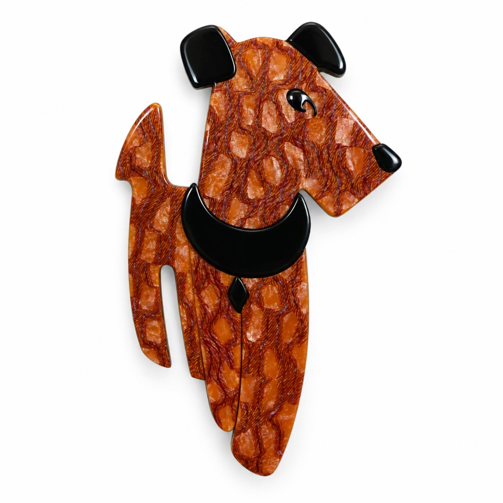 A decorative dog-shaped brooch made from patterned reddish-brown material with black ears, nose, and collar detail, shown against a plain light background.
