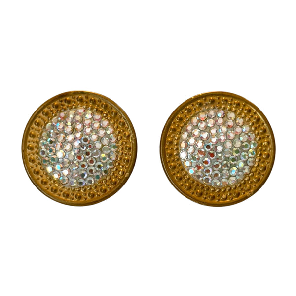 Pair of round gold earrings with gemstone-like center on a gray background