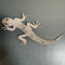 Decorative lizard brooch made of small stones on a dark surface
