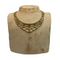 Gold necklace on a mannequin bust with a plain background