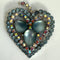 A sparkly brooch featuring three large iridescent blue-gray teardrop center stones surrounded by a border of small faceted blue-gray and iridescent rhinestones on a silver-toned setting.