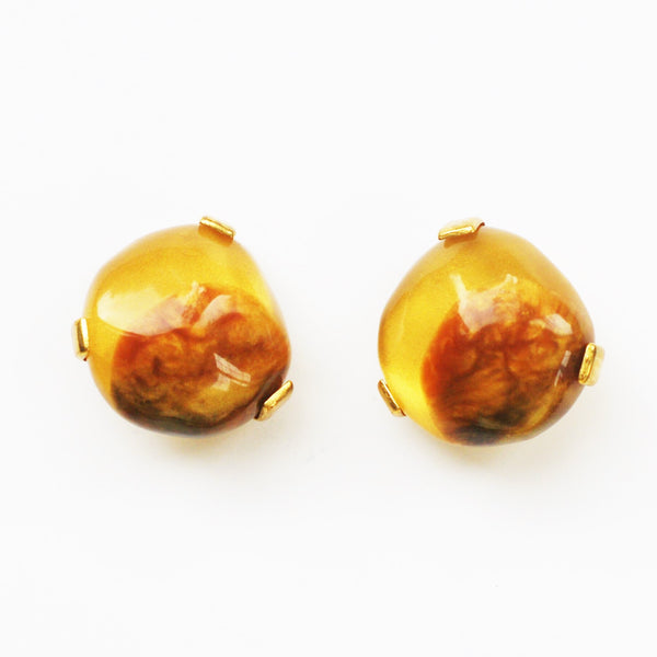 1980s vintage clip-on earrings in amber yellow and matt gold-plate on a white background