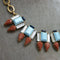 J crew vintage necklace with turquoise rectangular stones and pearshape deep red stones with a matte gold-plated chain