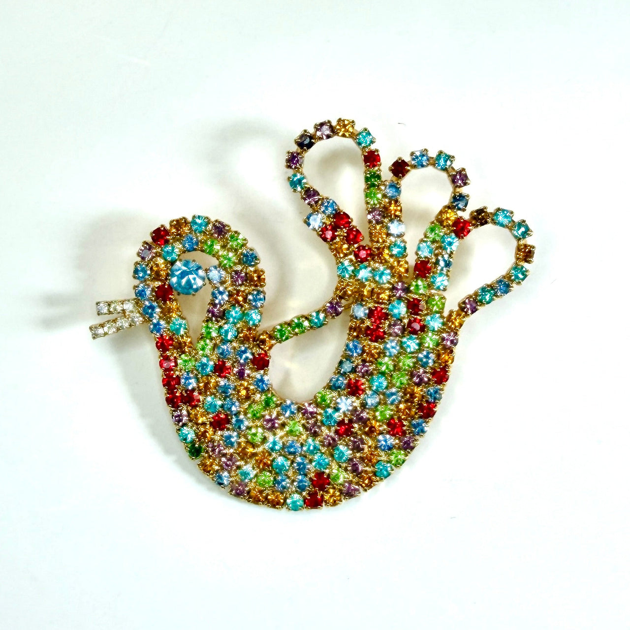 A colourful chicken shaped brooch or pin featuring a mix of red, green, blue, yellow, and orange rhinestones, photographed on a plain white background.
