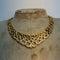 Gold necklace on a mannequin bust with a plain background
