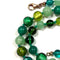 Green beaded necklace with a clasp on a white background