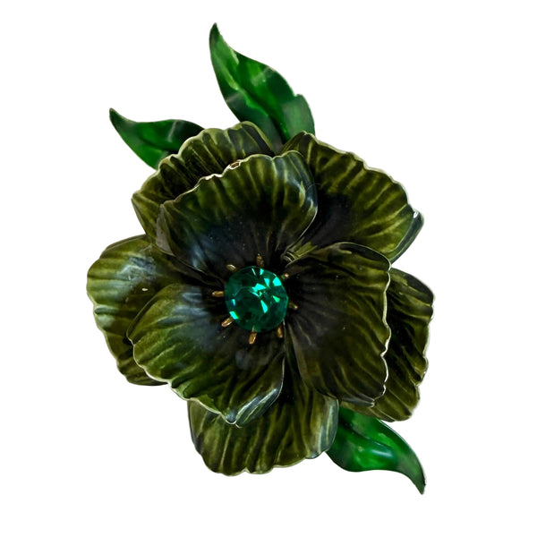 A vintage-style enamel flower brooch featuring dark green and black striped petals with a small green crystal center, set against a plain off-white background.