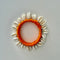 A handmade bangle with a vibrant orange  and white cowrie shells 
