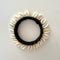 black wool and shell bangle on a white backfground
