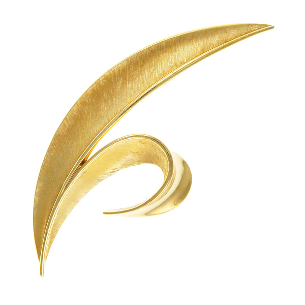 A gold-plated Trifari brooch with a brushed metal finish and a shiny leaf design.