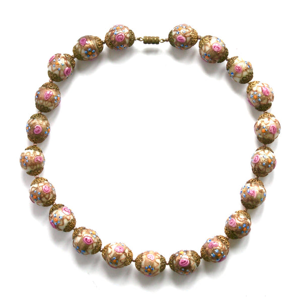 A vintage Venetian glass beads necklace with a combination of pink, beige, blue, and orange colors, and a metallic rose gold finish.